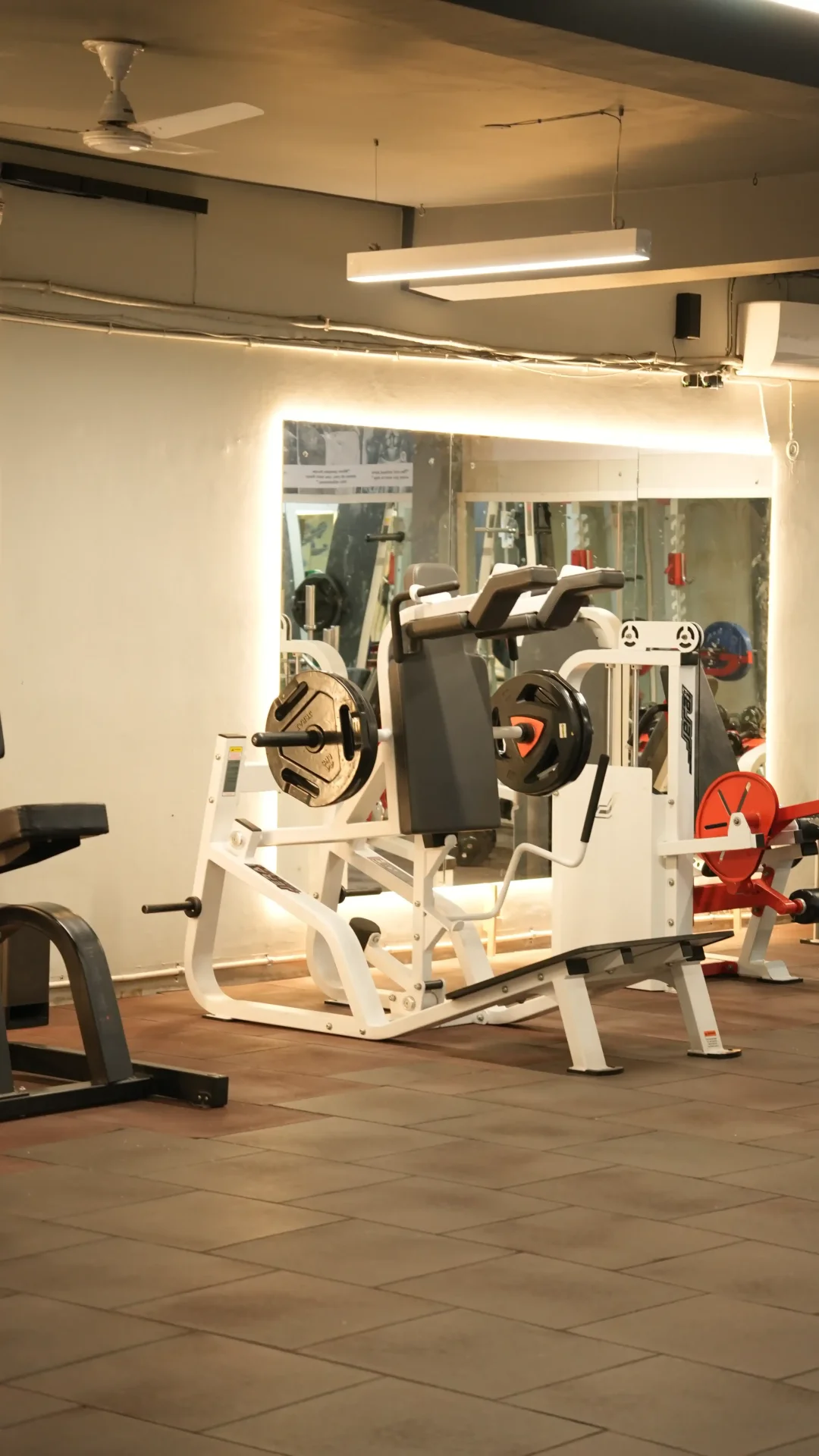 Leg press station with backlit mirror and equipment detail